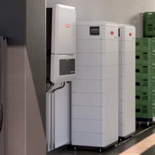 Fronius inverter og stablede batterimoduler i et lagerrum